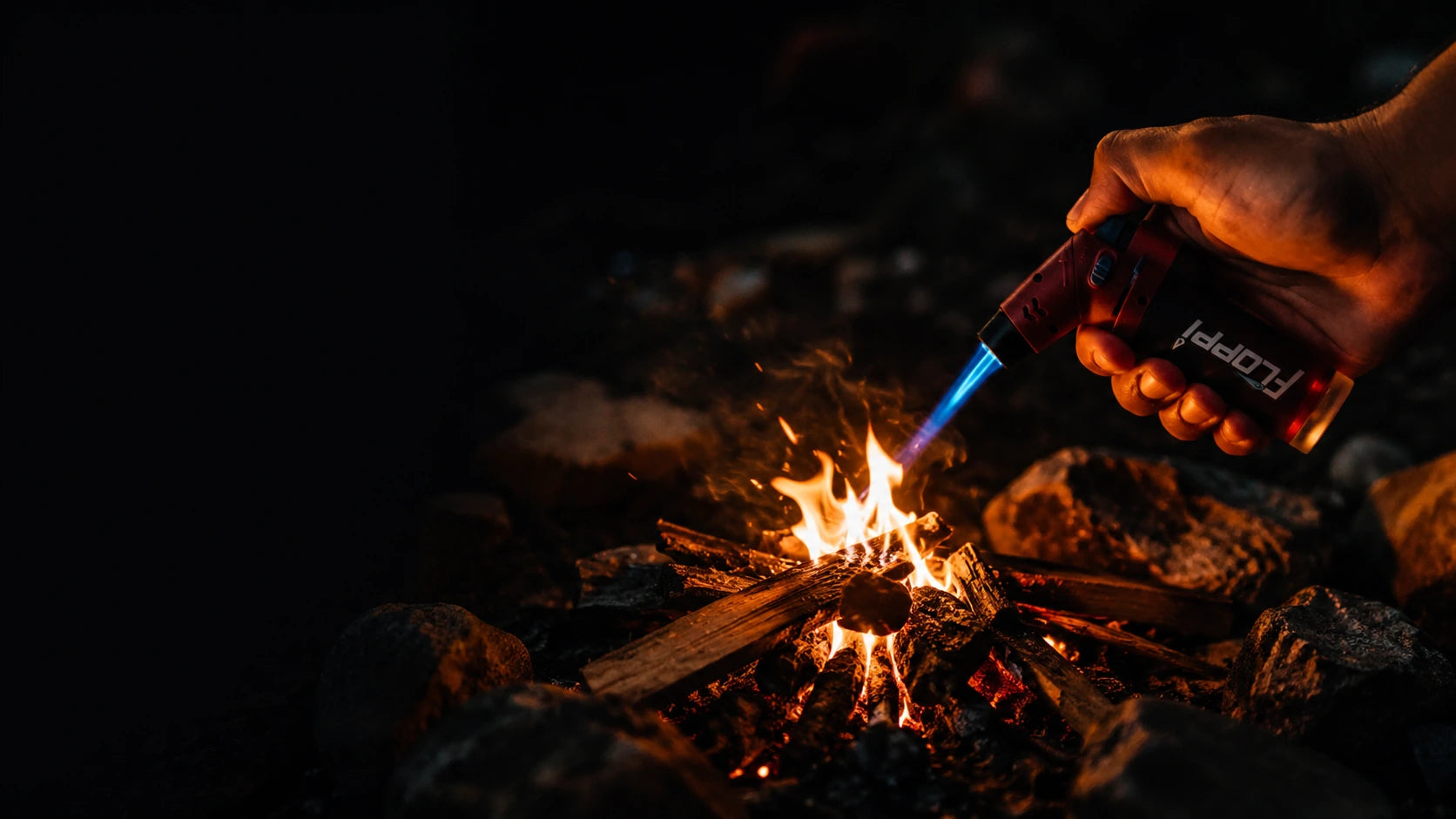 Encendedor Floppi encendiendo una fogata de noche en camping